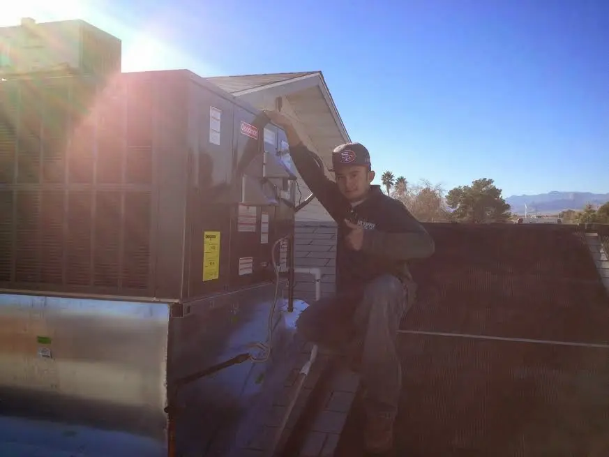 HVAC technician performing Heat Pump Repair on a rooftop unit in Newtown